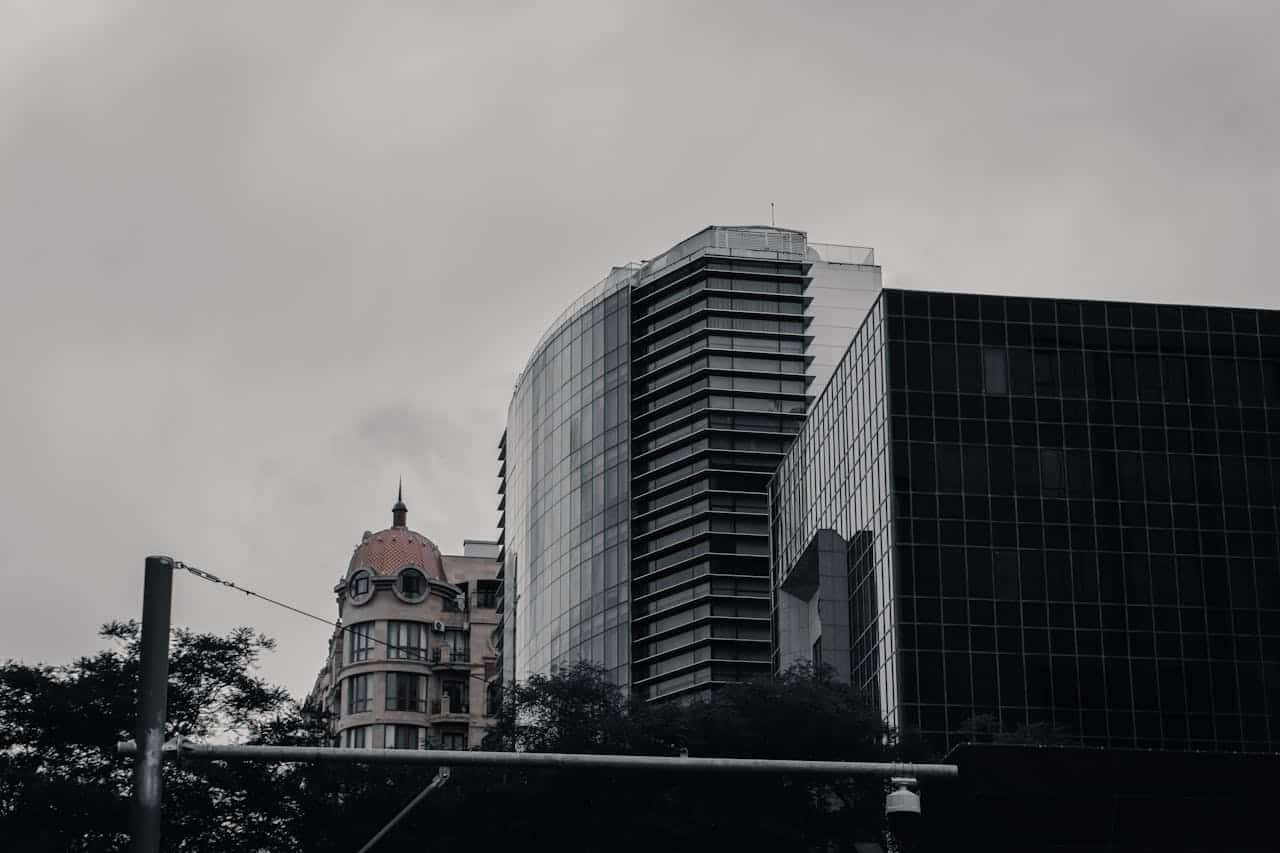 Glass and stone buildings in Baku, Azerbaijan under a cloudy sky, showcasing urban architecture.